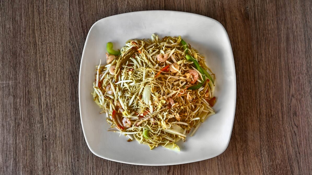 Singapore rice noodles from above: thin curry-yellow rice noodles tossed with shrimp, bean sprouts, green pepper, cabbage, carrot and egg.